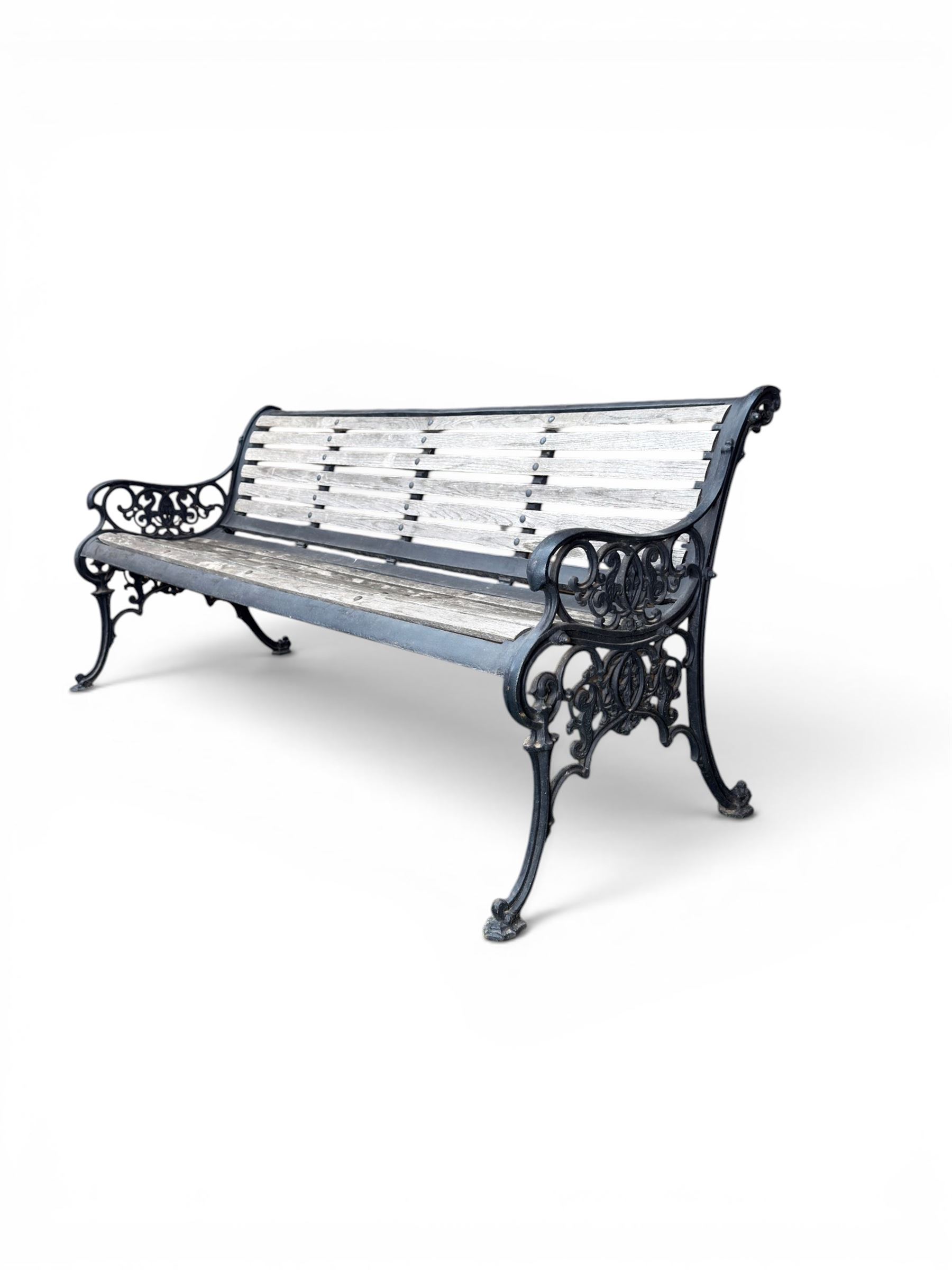 Victorian Andrew McLaren pattern cast iron bench, the ornate ends with detailed scrollwork, joined together with a cast iron seat and backrest frame supporting gently weathered oak slats, Victorian diamond stamp mark