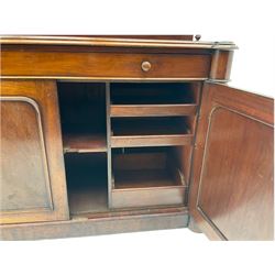 Victorian mahogany chiffonier side cabinet, the cresting rail carved with scroll leafage over two tier shelf back, moulded top over single drawer and double panelled cupboard, turned and fluted pilaster columns