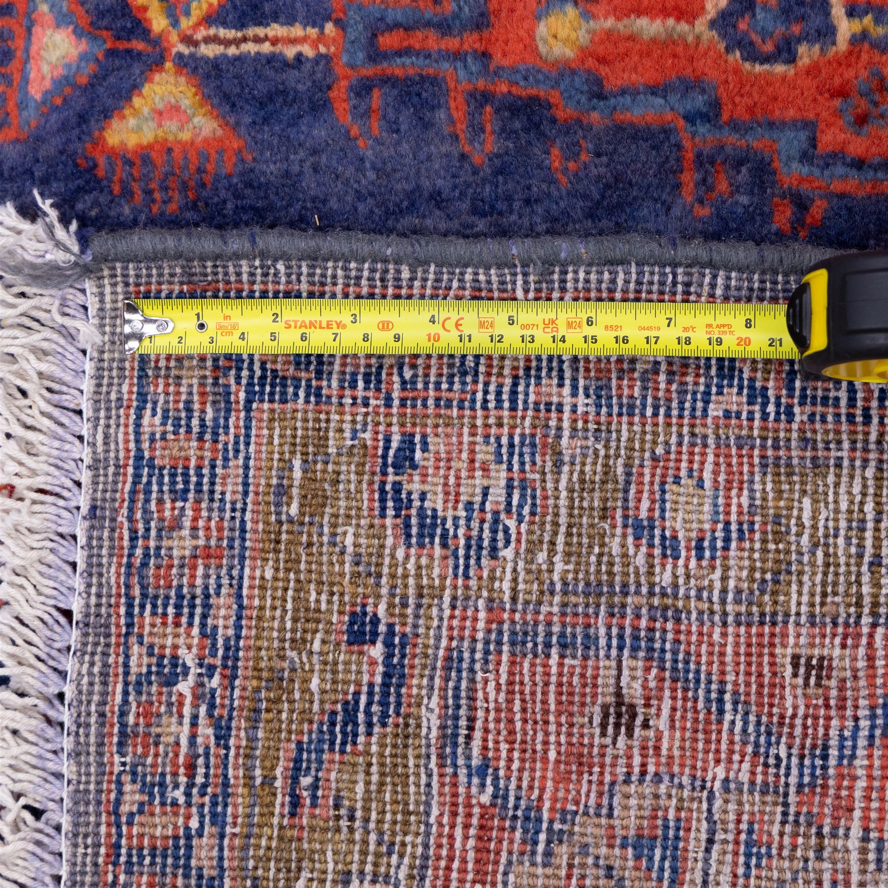 Central Persian Veis hand-knotted carpet, deep blue indigo field with central stepped lozenge medallion filled with stylized floral and geometric motifs, flanked by further angular medallions and tribal devices, edges with articulated and serrated hooked forms within a wide geometric border with repeating stylized floral motifs and multiple guard borders, in madder red, indigo blue, ivory, olive green, with cotton fringe ends
