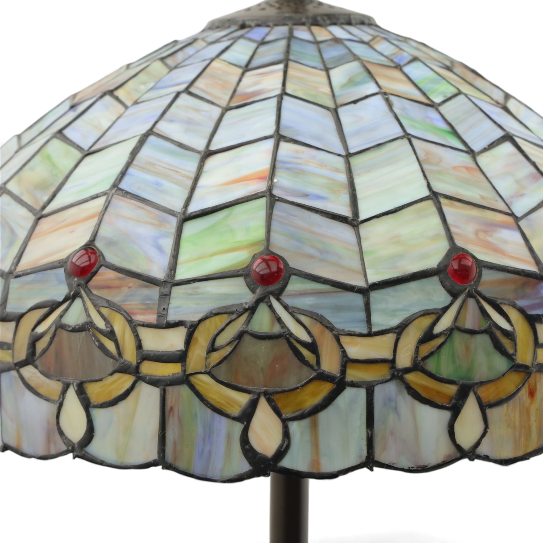 Late 20th century Tiffany style standard lamp, the leaded glass domed shade composed of geometric panels in mottled pastel tones, bordered by stylised foliate motifs and coloured cabochons, raised on a spiral twist metal column and circular moulded base
