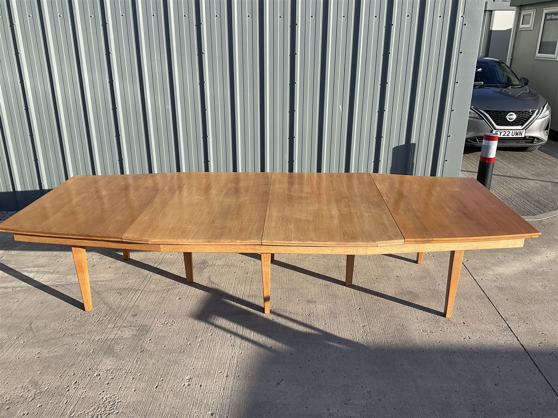Light oak bespoke boardroom table, concave form, four sectional top on square discreet legs (12' x 5'), with twelve armchairs including 'Chairmans' chair
