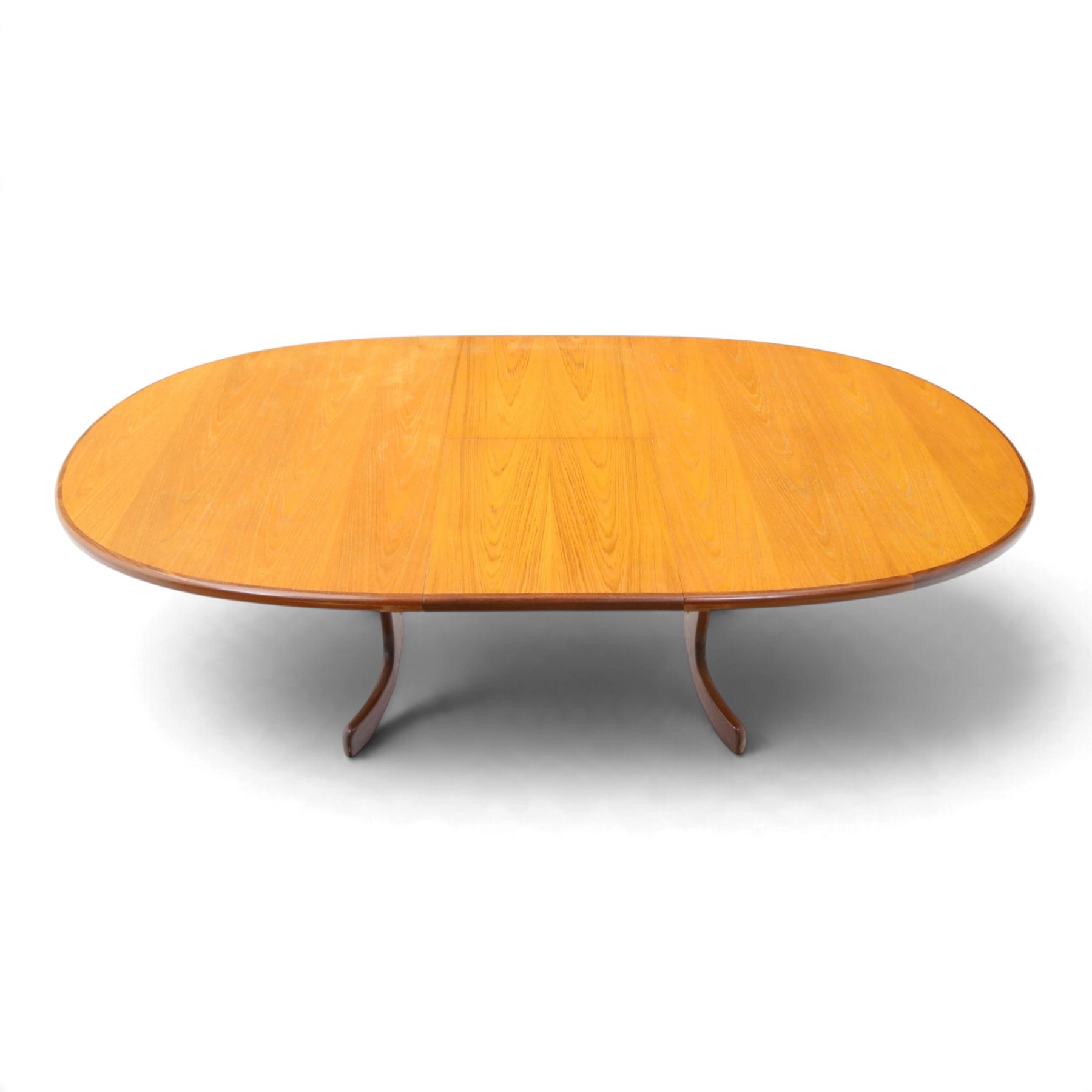 G Plan - Mid 20th century teak extending dining table and four chairs, oval top with stowed fold-over leaf extending to 208cm, raised on two shaped supports united by a stretcher 