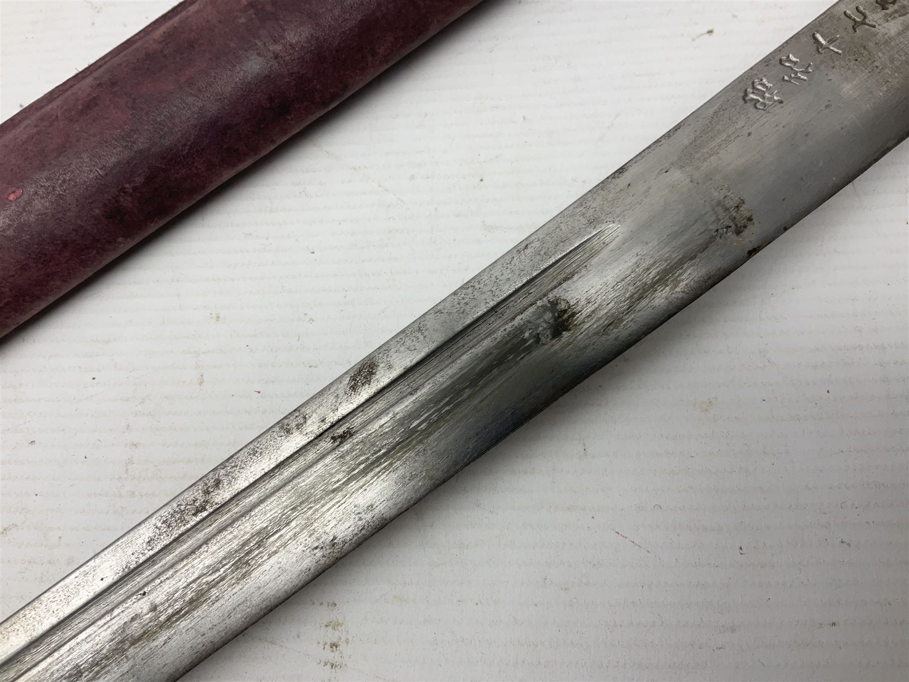 Copy of a WWII Japanese NCO sword, the 65cm slightly curving blade stamped with pseudo Japanese characters and cast brass simulated cord bound grip; in officer's leather bound field scabbard L97cm overall