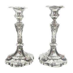 Pair of late Victorian heavy gauge silver candlesticks, each with filled shaped circular spreading base leading to an inverted baluster stem and urn shaped socket with removable circular nozzle, decorated with mask heads, acanthus leaves and scrolls, hallmarked John Round & Son Ltd, Sheffield 1897, H19cm 