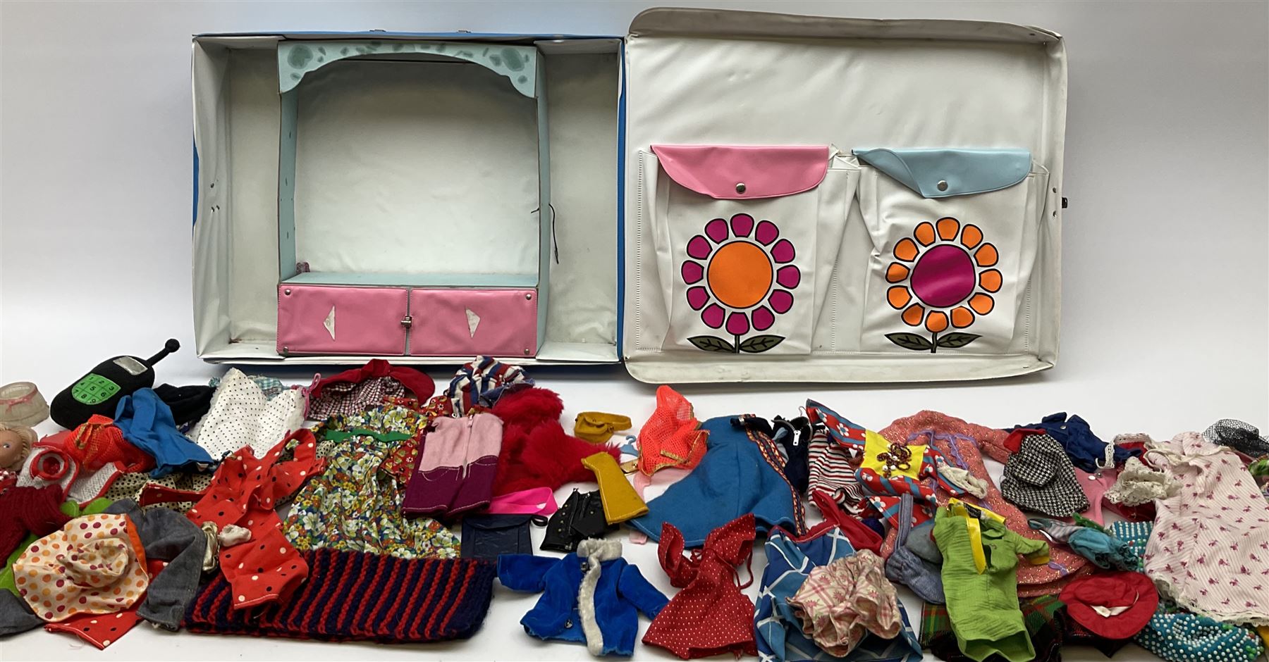 The World of Barbie Double Doll Case containing a quantity of assorted doll's clothing; together with two large and one small fashion dolls.