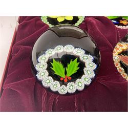 Set of four Caithness paperweights titled Four Seasons, in presentation box with certificate, designed by Colin Terris and made by William Mason, each internally decorated with a seasonal flower within a millefiori cane work garland, numbered 128 of 500