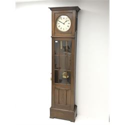 Early 20th century oak longcase clock, projecting cornice over plain dial with Roman numerals, the trunk enclosed by astragal glazed door with panel, twin weight driven eight day movement striking the hours and half on coil
