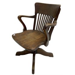 Early 20th century swivel office desk chair, shaped bar back over vertical rails, dished seat, on four splayed supports