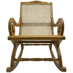 Late 20th century teak framed plantation style rocking chair, cresting rail carved with two elephants with upraised trunks, cane back and seat with scrolled arm terminals, rocker base united by turned stretcher