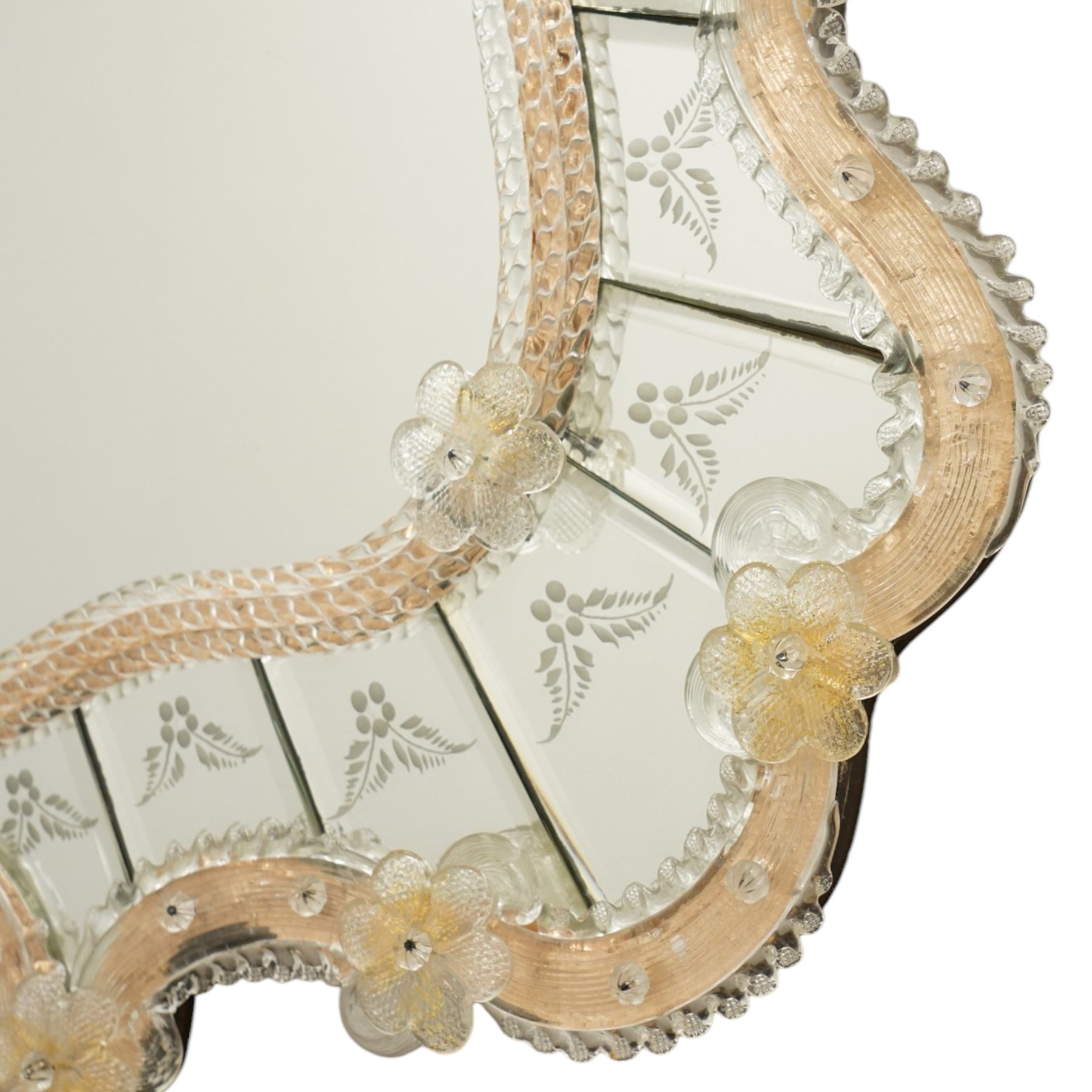 20th century Venetian glass wall mirror, the shaped plate within a mirrored frame applied with clear glass flowerheads and moulded glass edging, with etched floral decoration to the bevelled 'frameless' plates, the inner slip with ropetwist moulded glass