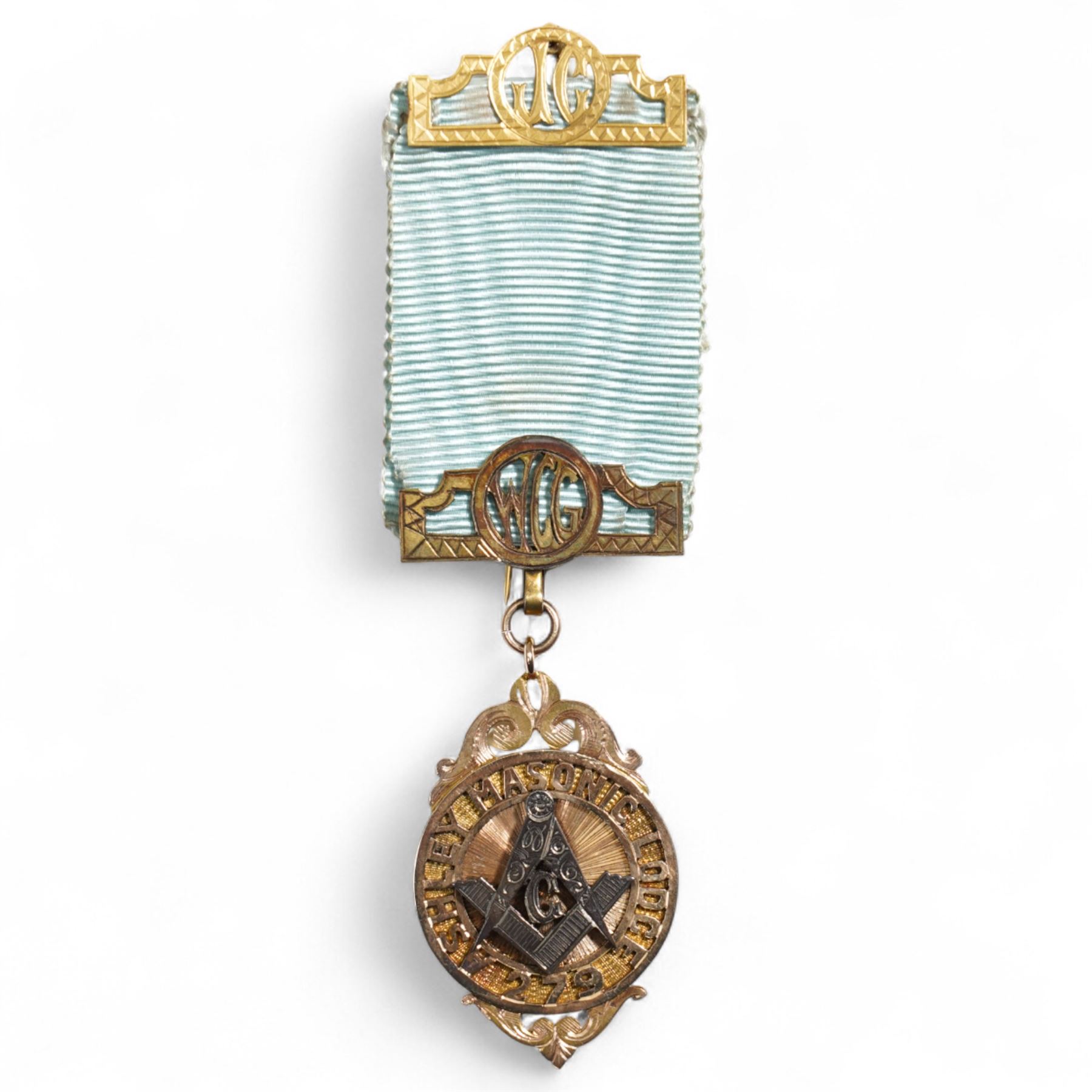 Early 20th century gold presentation Masonic jewel,  'Ashley Masonic Lodge 279', stamped 9ct, with applied silver emblem, on gilt mounted ribbon, the reverse with inscription 'Presented to John Gray 1929'
