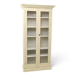 Traditional white painted pine display cabinet, projecting cornice above two glazed doors ...