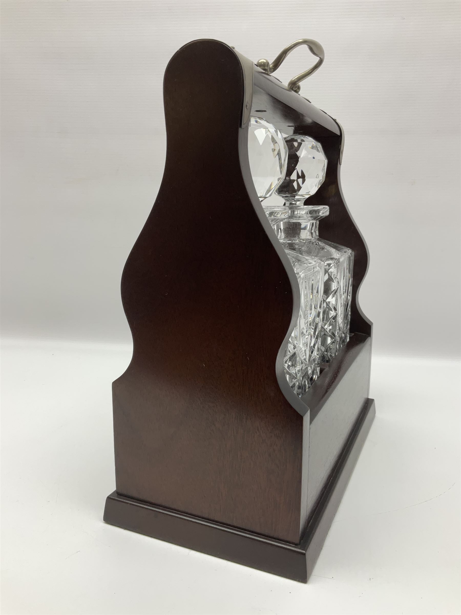 20th century mahogany tantalus with plated mounts and handle, with two recesses containing two square sided cut glass decanters, with key, including handle H36cm W27cm