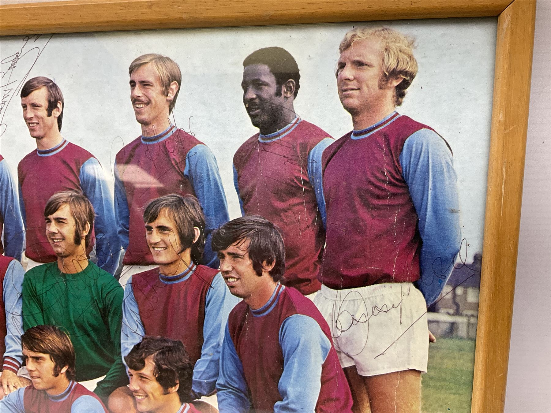 1970-1 photograph of West Ham United FC squad members, including Bobby Moore, Geoff Hurst, Harry Redknapp, Trevor Brooking, Jimmy Greaves, Billy Bonds etc, most players with signatures, 30 x 45cm, framed and glazed