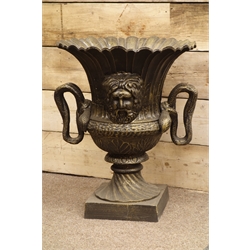 Large bronze finish circular pedestal urn, wavy border, twin snake handles, mask features, W62cm, H73cm