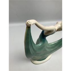 Early 20th century Hertwig Katzhütte figure of an Art Deco lady dancing, wearing a green, blue and yellow dress, stood upon on a domed plinth, with green cat H house printed mark beneath, H32cm