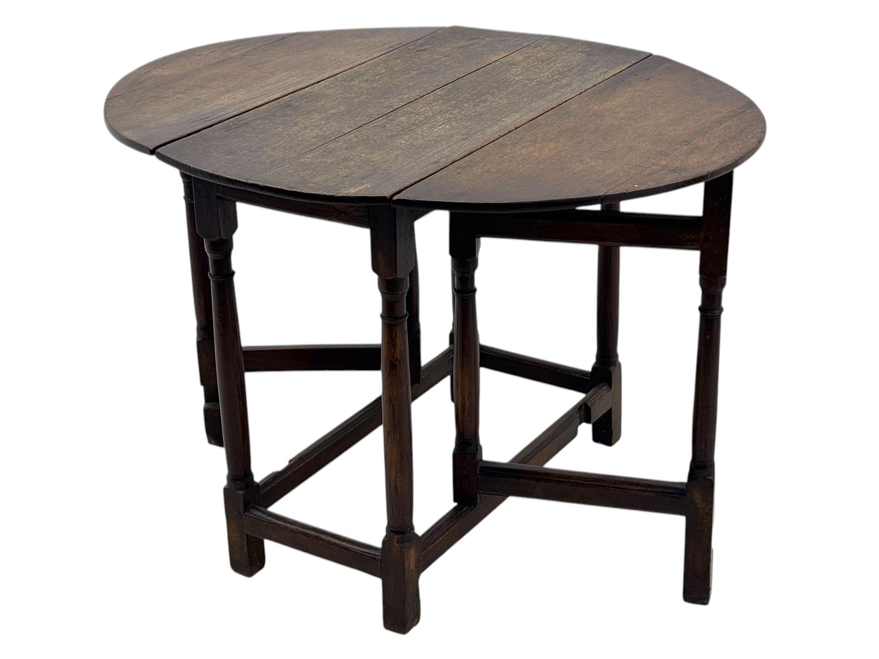 19th century oak gateleg table, the oval drop-leaf top formed of four planks, on turned column supports united by rectangular stretchers