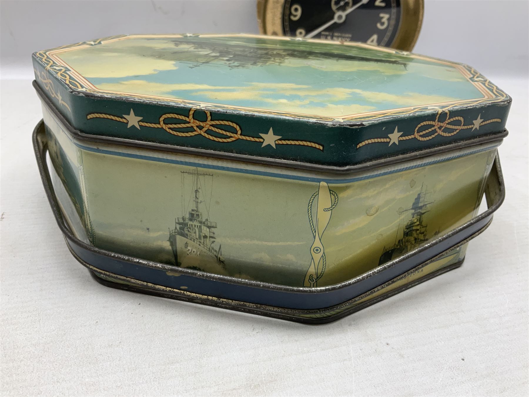 WWII period US Navy Mark I deck clock, the black circular dial with Arabic numerals,  luminous dot markers and subsidiary seconds dial marked 'Mark I Deck Clock U.S. Navy 15211 1941', in bronze bulk head case D20cm; and a Loose-Wiles Biscuit Company octagonal tin decorated with nine different US Warships (2)