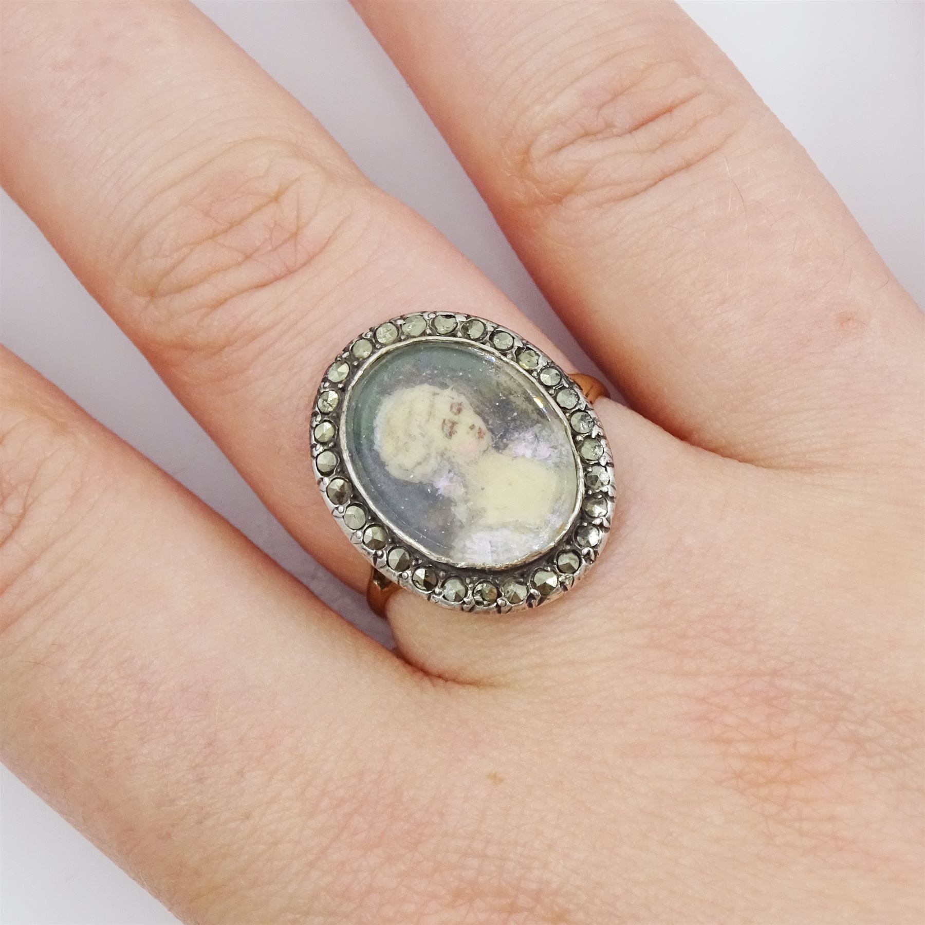 19th century French 18ct gold and silver marcasite portrait ring, set with an oval miniature of a woman on ivory, under glazed panel, with marcasite surround and trifurcated shoulders, hallmarked. This lot has been registered for sale under Section 10 of the APHA Ivory Act