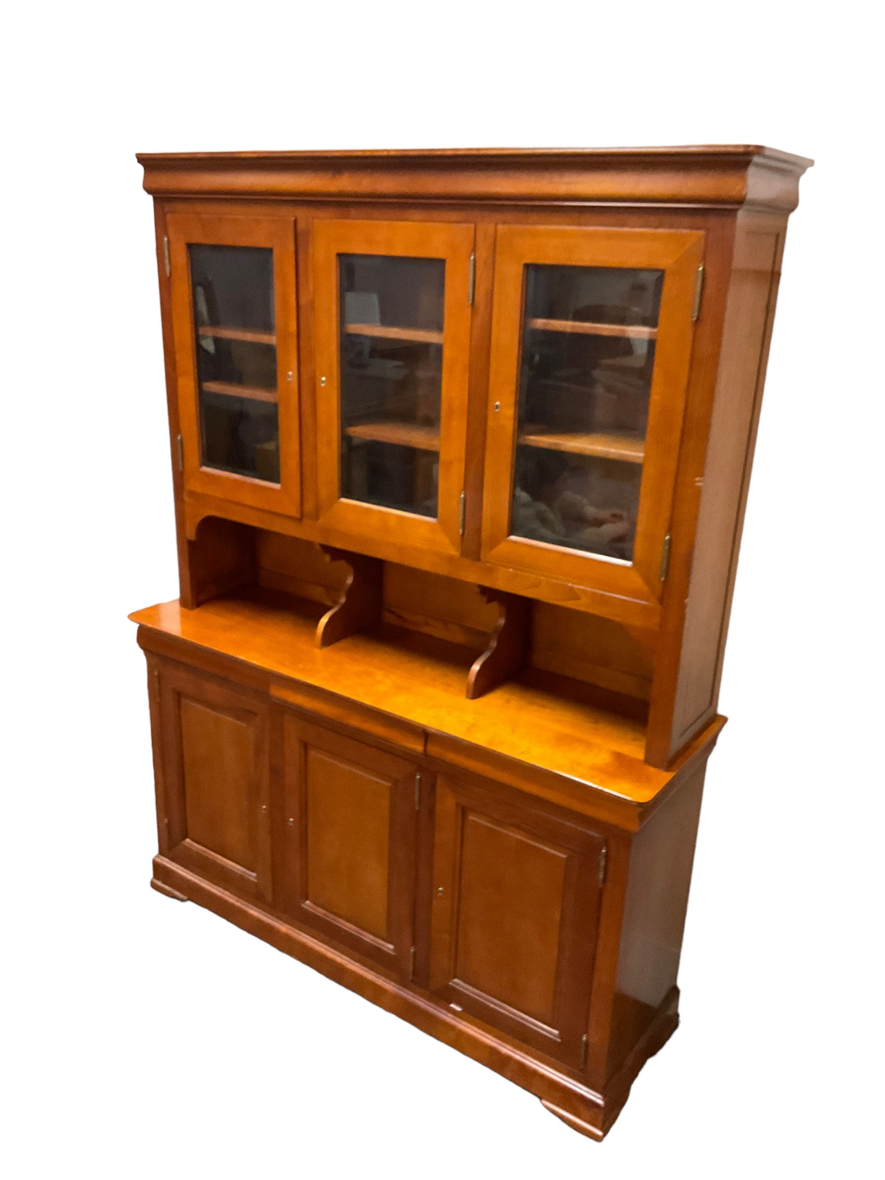 Multi-York -  Loire cherry wood dresser, shaped cornice over three glazed doors enclosing six shelves, the lower section fitted with three shallow drawers with shaped fronts over three cupboards with panelled doors, raised on plinth base with bracket feet