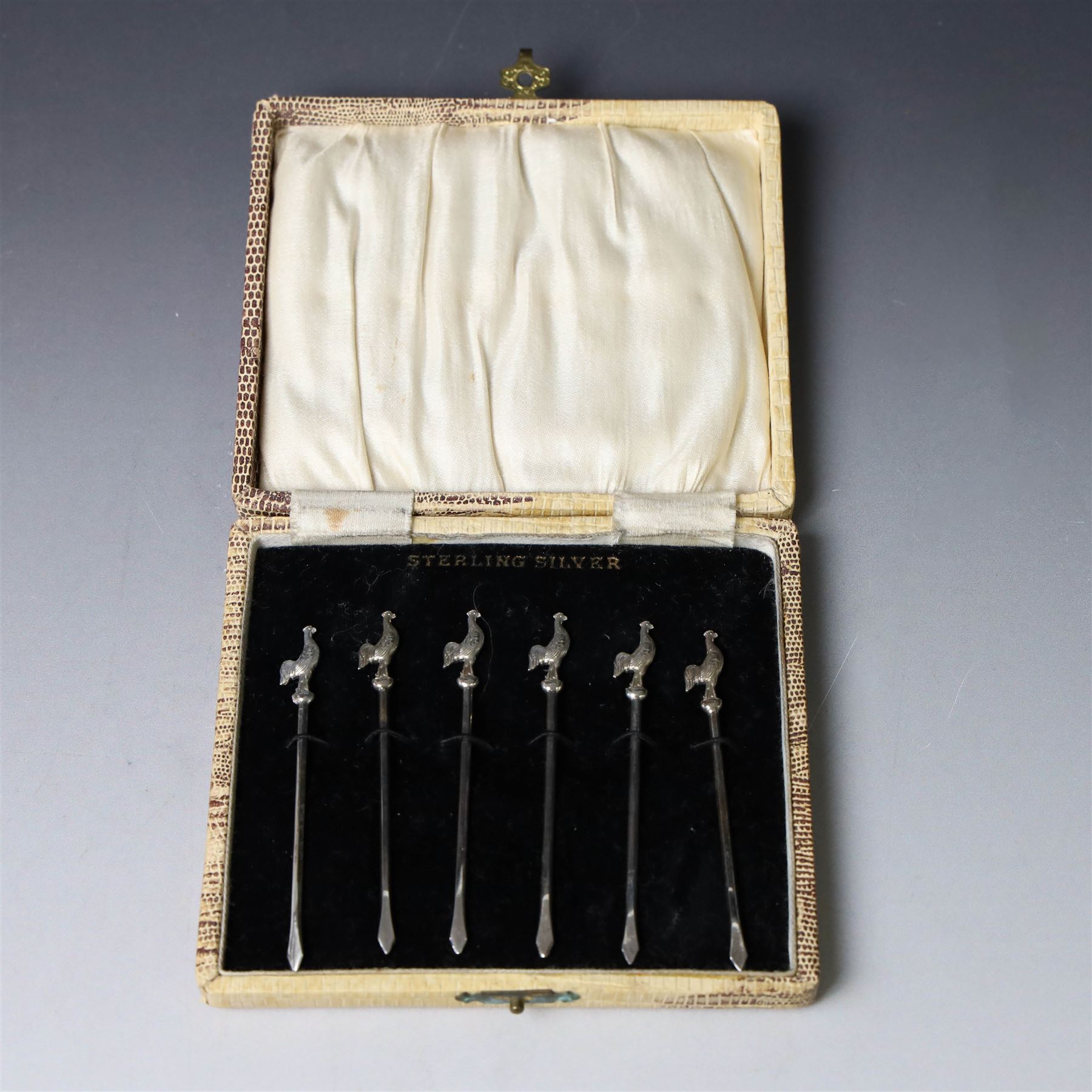 Set of six silver cocktail sticks, each with cockerel finials, stamped Sterling Silver, in fitted case