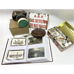 Postcards including WW1 silk postcards, local interest and photographic postcards, gas mask in box, material tape measure and metal sign. 