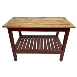 Pine kitchen table, rectangular bread boarded plank top over red painted splayed supports and pot board base