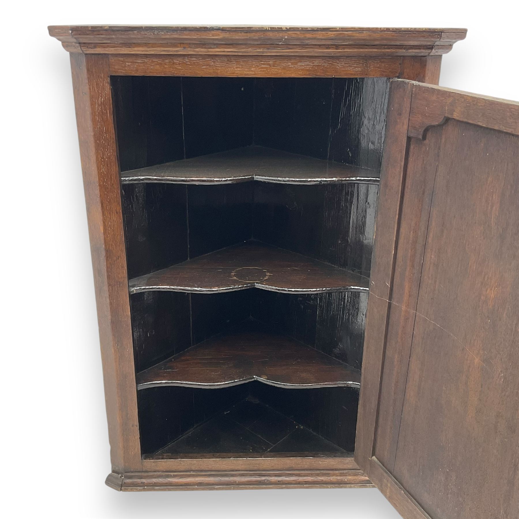 Early 20th century wall mounted oak corner cabinet, moulded cornice over panelled door enclosing single fixed shelf (W60cm, D40cm, H66cm); 19th century oak corner cabinet, panelled door enclosing three shaped shelves (W65cm, D35cm, H92cm)