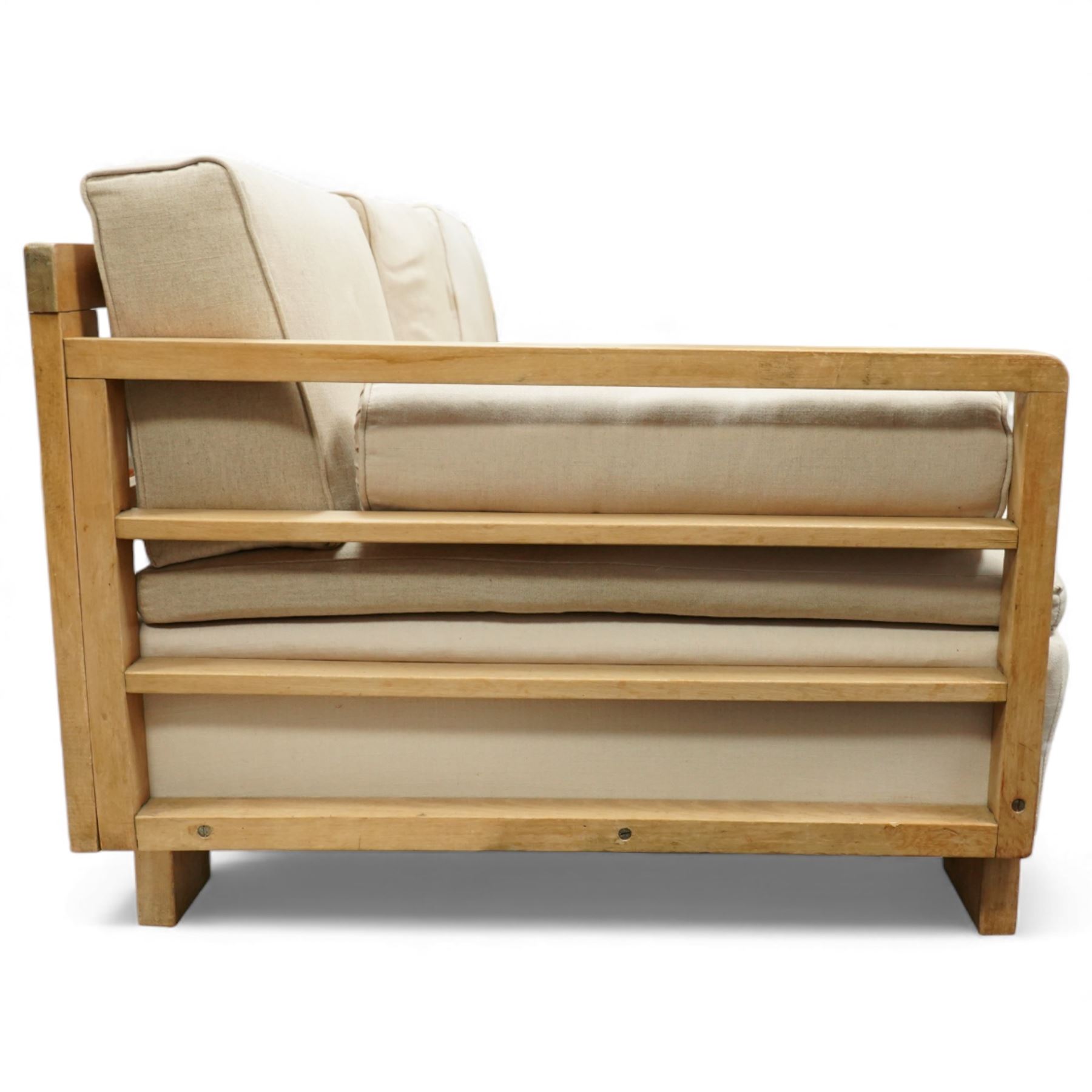 Mid 20th century German Art Deco oak framed divan day bed, rectangular form with slatted side supports, upholstered in cream linen with three removable back cushions, three seat cushions and cylindrical bolster arms, on block feet