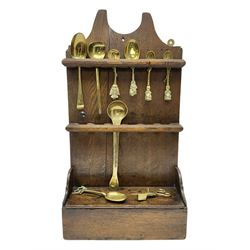 George III oak spoon rack and candle box, the rectangular backplate with shaped  pediment and two six aperture spoon racks, above a candlebox with hinged cover, with various brass spoons and a pair of brass candle snuffers, H56.5cm, W35cm, D14cm 