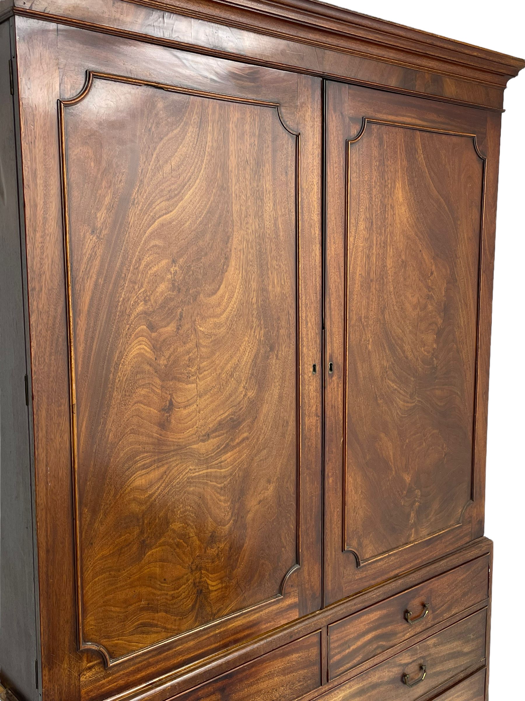 George III mahogany linen press, projecting cornice over two figured doors enclosing five linen slides, the lower section fitted with two short and two long drawers, on bracket feet