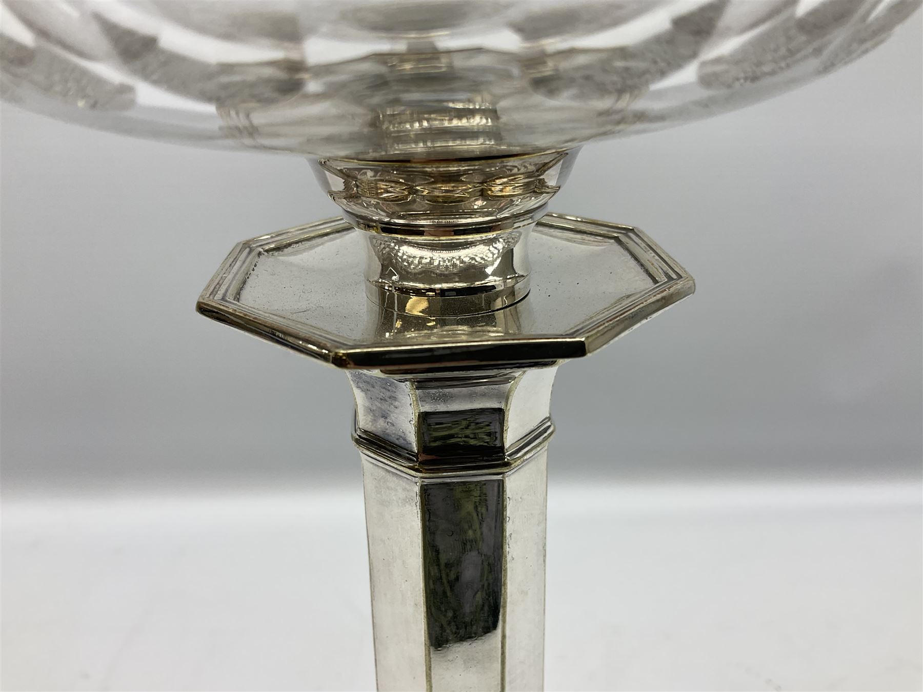 20th century Hawksworth, Eyre & Co silver plated oil lamp, the octagonal stepped base with engraved dedication, leading to an octagonal column supporting a faceted clear glass reservoir, Hinks Duplex burner, clear glass chimney, and cranberry glass shade, overall H71.5cm