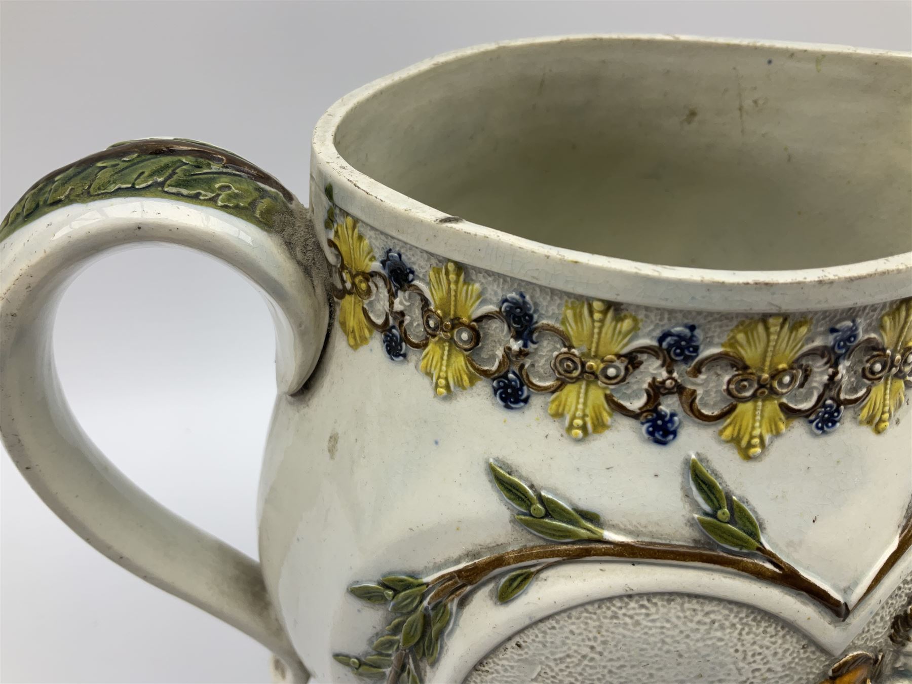 Early 19th century Prattware jug, circa 1800, decorated with two heart shaped panels of children, titled Sportive Innocence and Mischievous Sport, further decorated with acanthus and foliate borders, H22cm