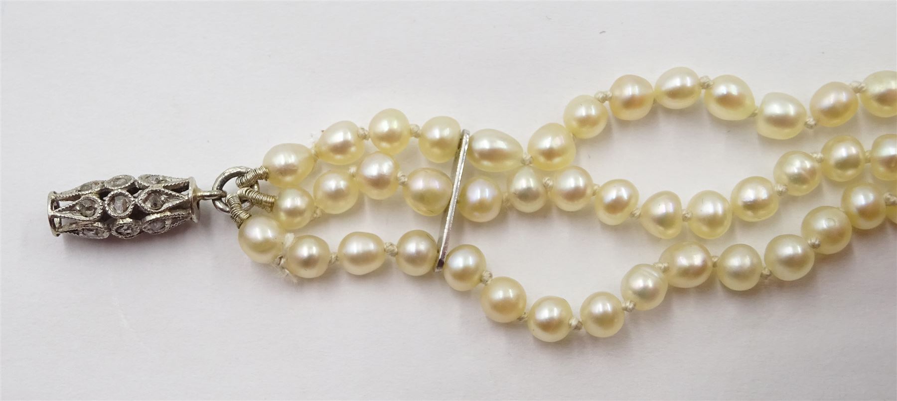 Three strand pearl necklace, with platinum diamond milgrain clasp and a single strand graduating pearl necklace with 18ct white gold clasp set with a diamond