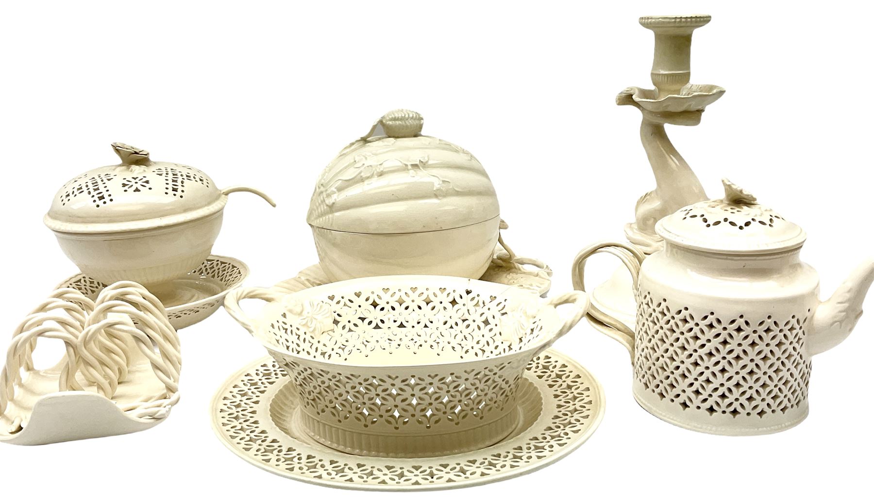 20th century Leeds creamware, comprising chestnut basket and stand, small tureen and cover, ladle, and associated stand, candlestick with stem modelled as a dolphin, teapot, tureen and cover in the form of a melon with fixed stand, and toast rack (toast rack a/f), each with impressed mark beneath. 
