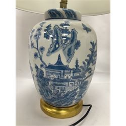 Pair of blue and white table lamps, each of ovoid form, decorated with a continuous landscape, raised upon circular gilt base, excluding fittings H35cm 