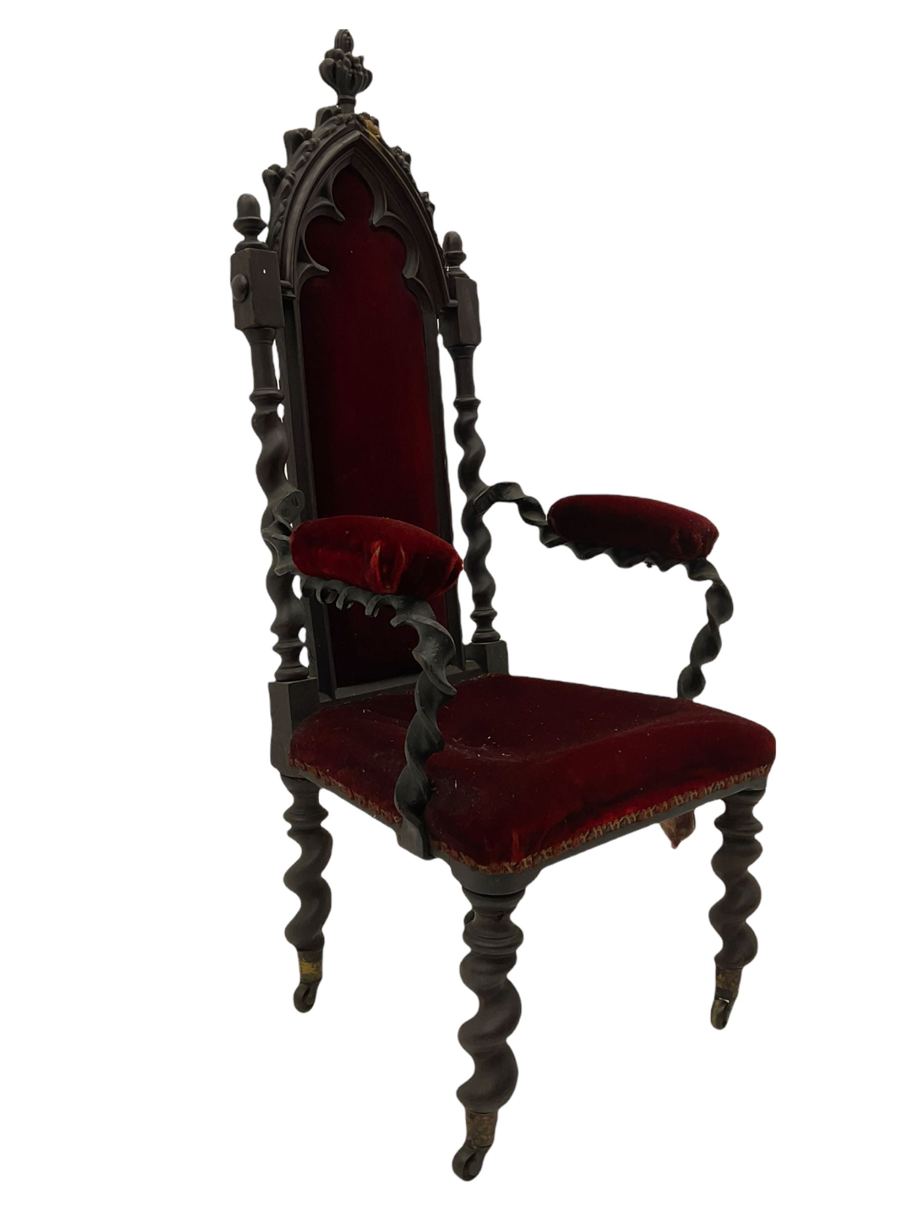 Victorian oak and wrought metal Gothic open armchair, the pointed arched back carved with foliate, cusped inner arch upholstered in red, spiral turned uprights and supports, with arms made of spiral forged metal