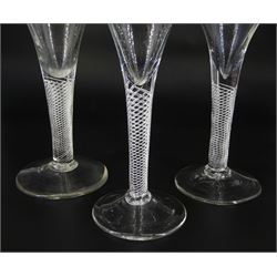 Three 18th century drinking glasses, the drawn trumpet bowls upon single series air twist stems and conical feet, tallest H16.5cm