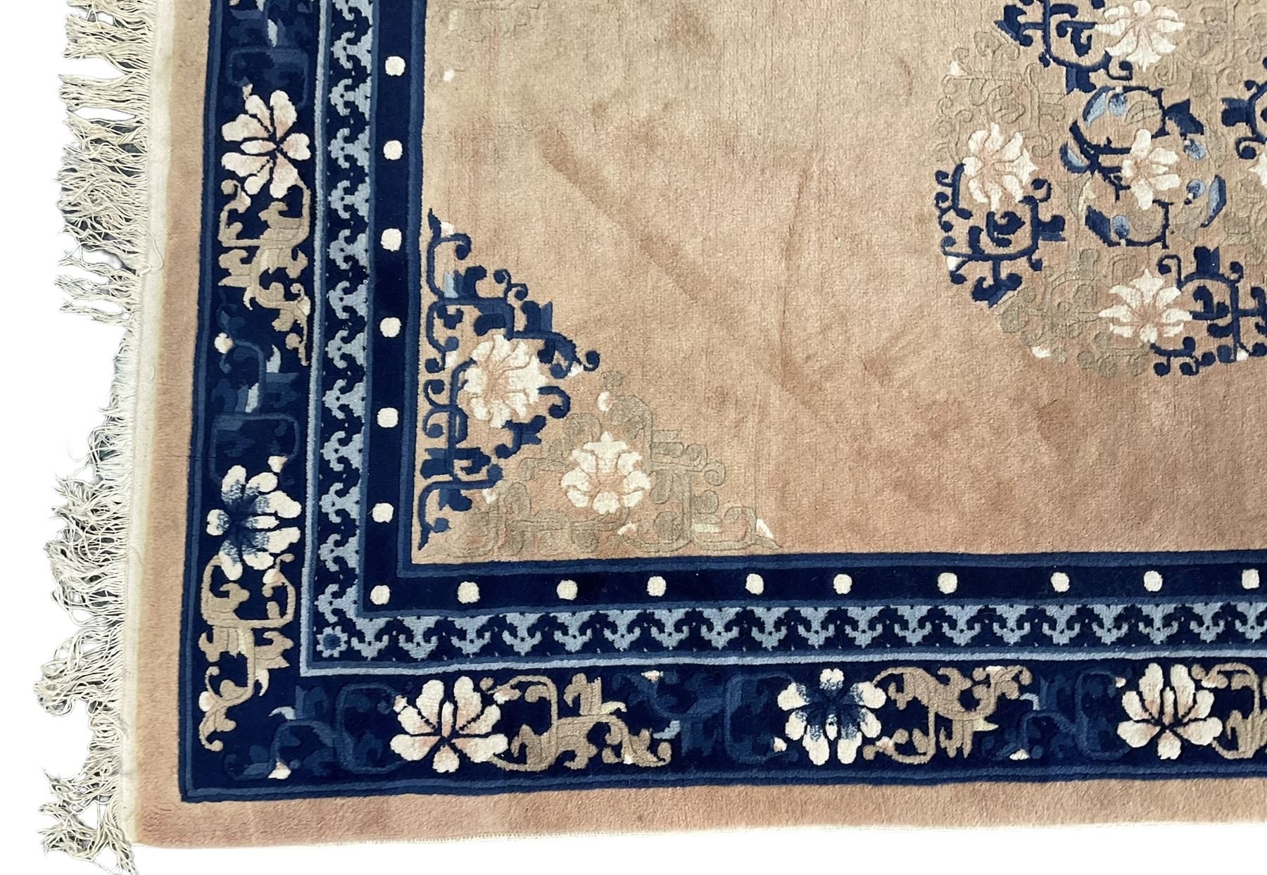 Chinese washed woollen peach ground rug, indigo borders and trailing foliate decoration, central medallion decorated with flowerheads 