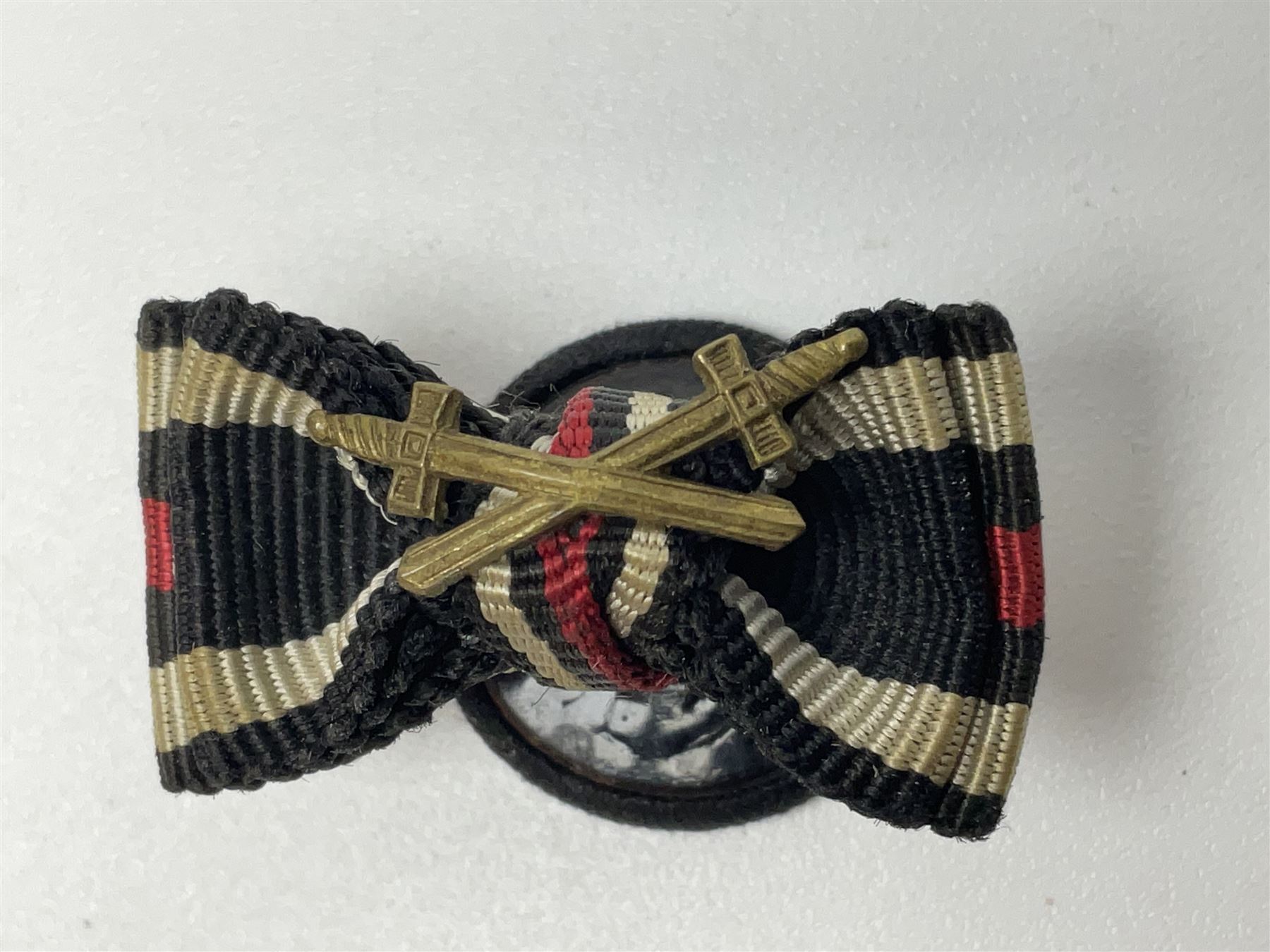 Four German awards - pre-WW2 two-position button hole ribbon for 1914 Iron Cross; WW1 wound badge open back cut-out version with silvered finish; miniature version Mother's Cross with ribbon bow; and The Eastern Medal, officially the Winter Battle in the East 1941–42 Medal (4)