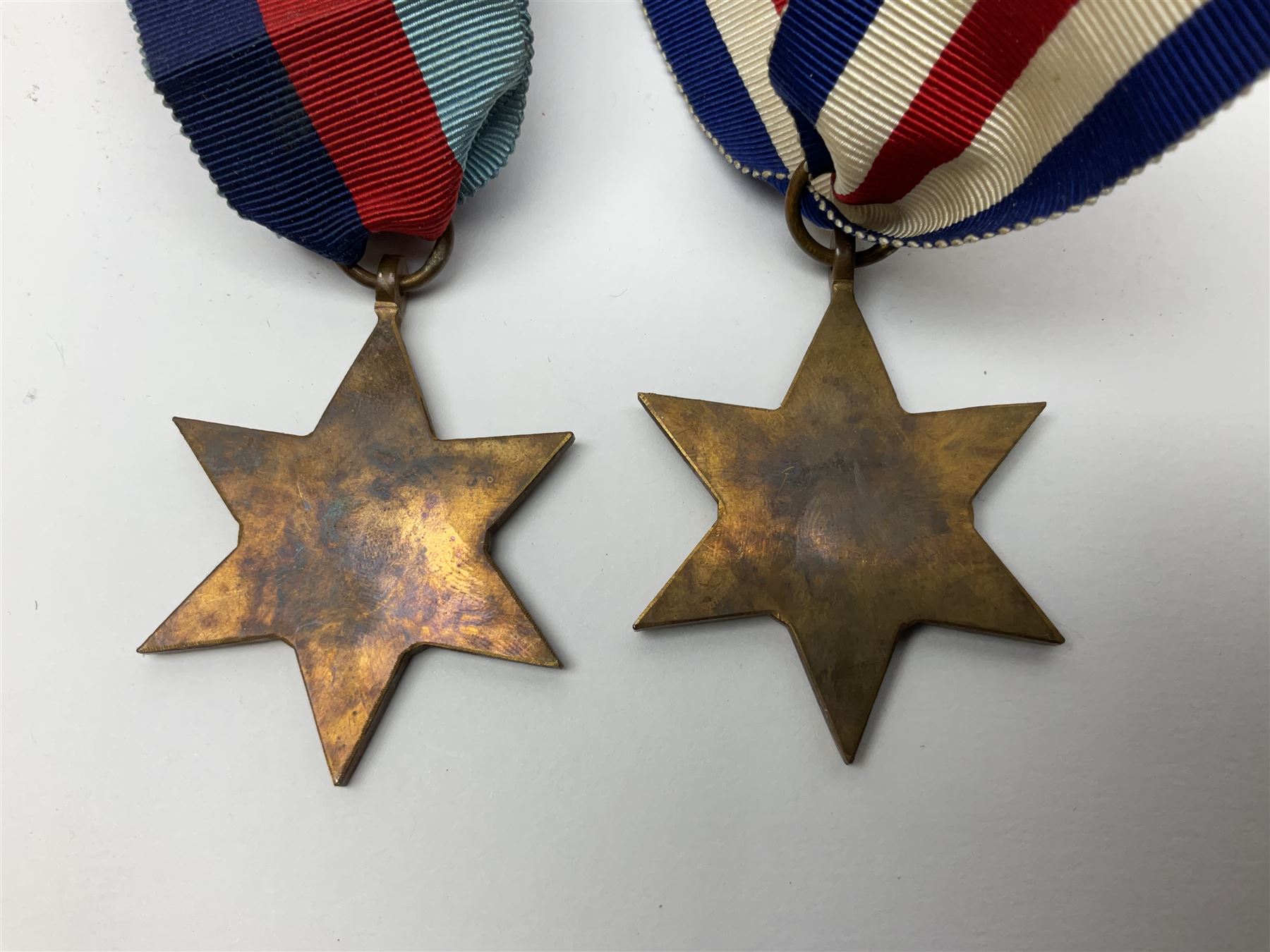 WW1 pair of medals awarded to 151761 Gnr. S. Loten R.A. with ribbons; four WW2 medals with ribbons; and small quantity of cap badges, medallions etc