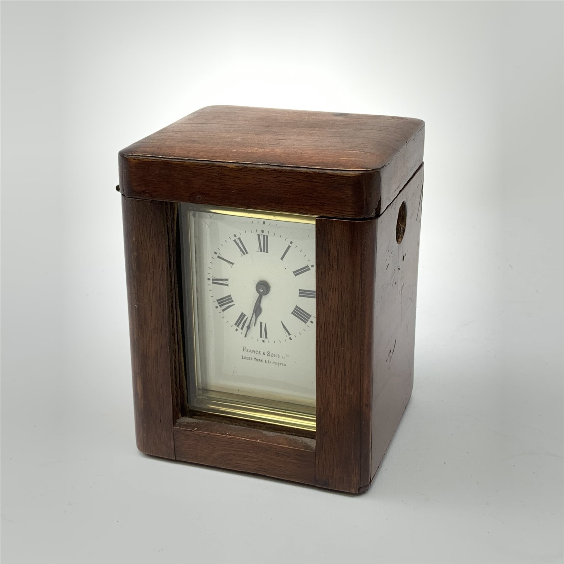A brass cased carriage clock, the white enamel dial with black Roman numerals, marked Pearch & Sons Leeds, York & Leicester, including handle H14cm, in fitted case. 