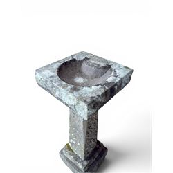 19th century weathered sandstone birdbath, formed in four sections, square top with carved shell bath, raised on tapering column with stepped base