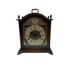 A late 20th century Westminster chiming mantle clock, chiming the hours and quarters on 5 gong rods, 8-day three train spring driven German movement with an adjustable floating balance, gilt brass dial with brass spandrels, etched matted dial centre and silvered chapter ring, Roman numerals, minute track and pierced gothic steel hands, movement manufactured by Bentima, mahogany finished case with finials and carrying handle raised on four paw feet.





