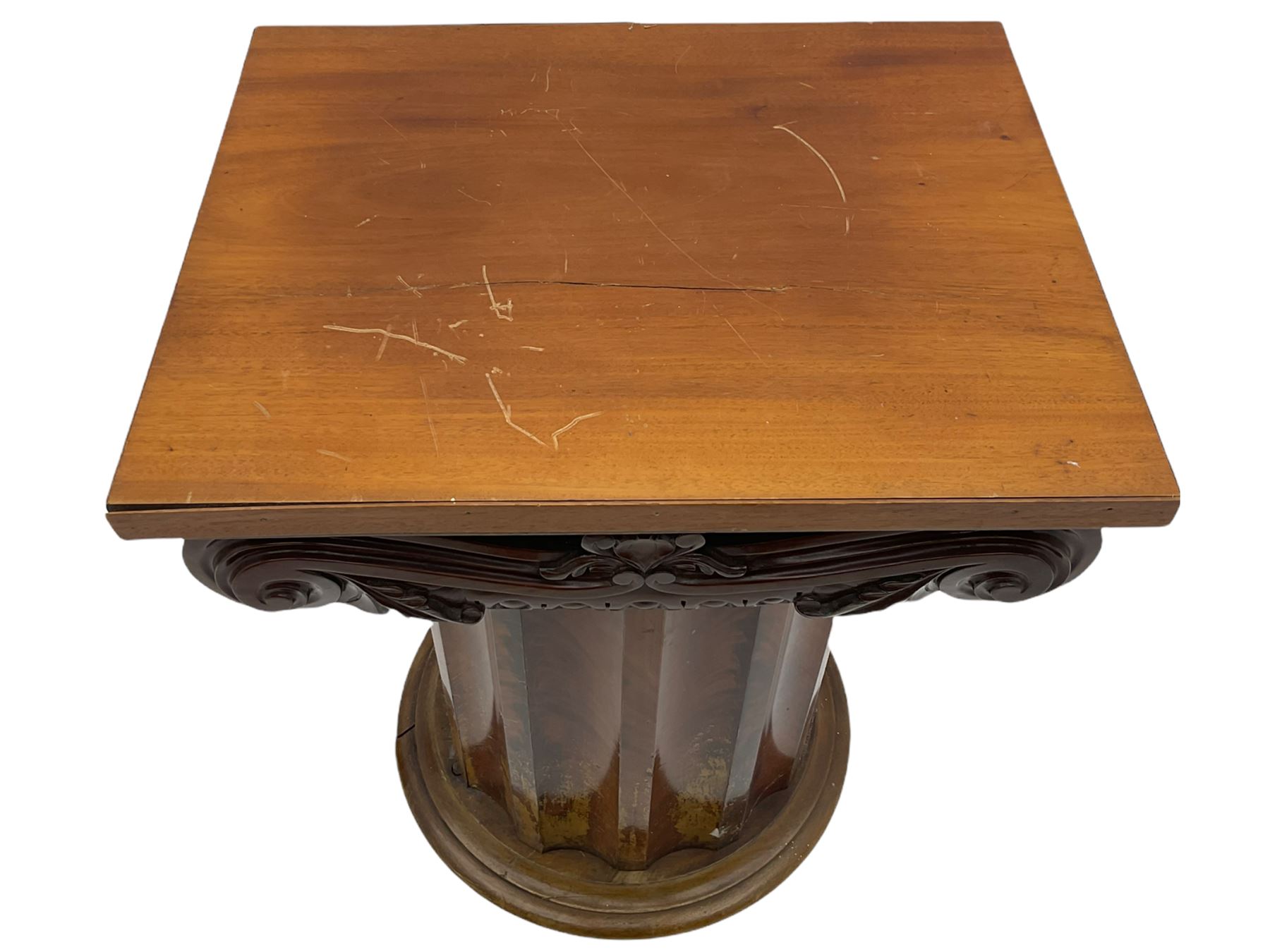 Victorian mahogany vanity unit in the form of a column, the scrolled top with hinged lid revealing mirror, wash bowl and toiletry dishes, on scalloped cylinder pedestal with single door, the interior fitted with shelf