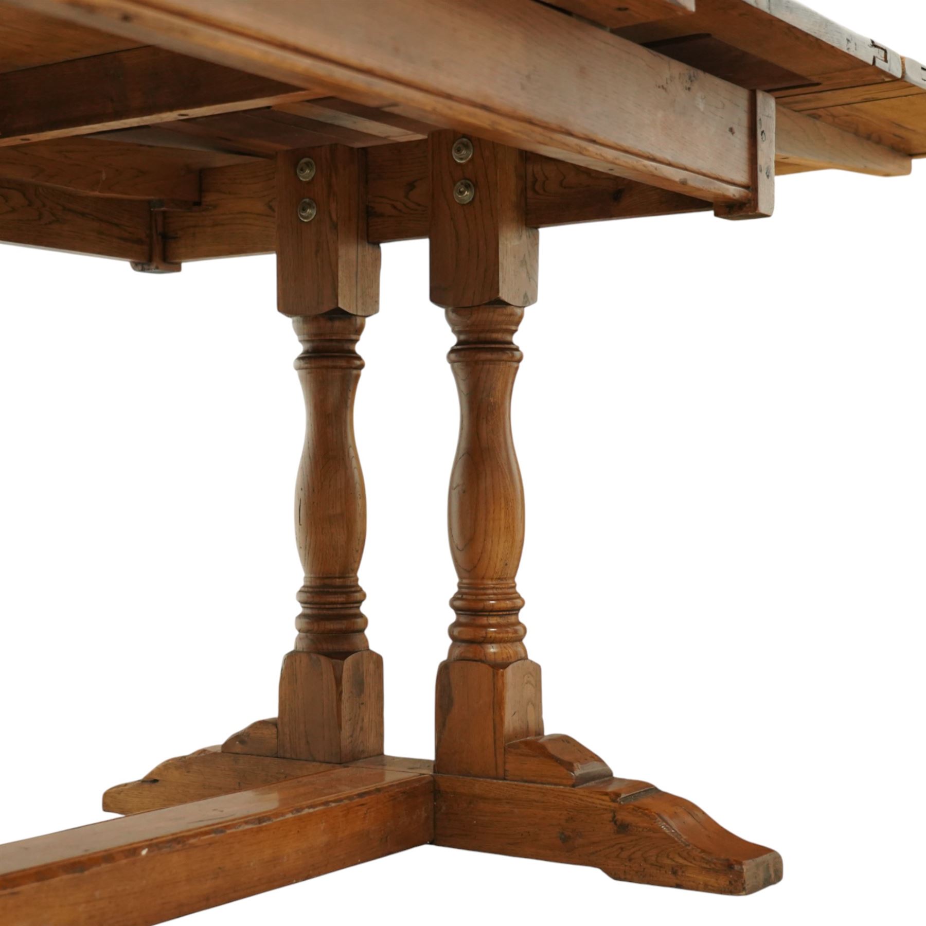 Late 20th century light oak extending refectory table, in the manner of Titchmarsh & Goodwin, rectangular plank top with cleated ends and two draw leaves extending to 260cm, supported on turned end supports united by a stretcher, raised on block feet