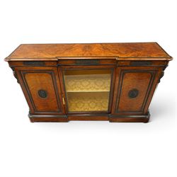 Lamb of Manchester (est. 1843) - Victorian Aesthetic Movement inlaid figured and burr walnut inverted-breakfront credenza, the shaped rectangular top with ebony banding and boxwood stringing, the frieze applied with bronze mounts decorated with foliate and scroll motifs, fitted with central glazed door flanked by panelled doors with central oval metal plaques depicting Classical Muses with lyre, the flanking canted uprights applied with caryatid maidens holding torches, acanthus terminal over skirted base