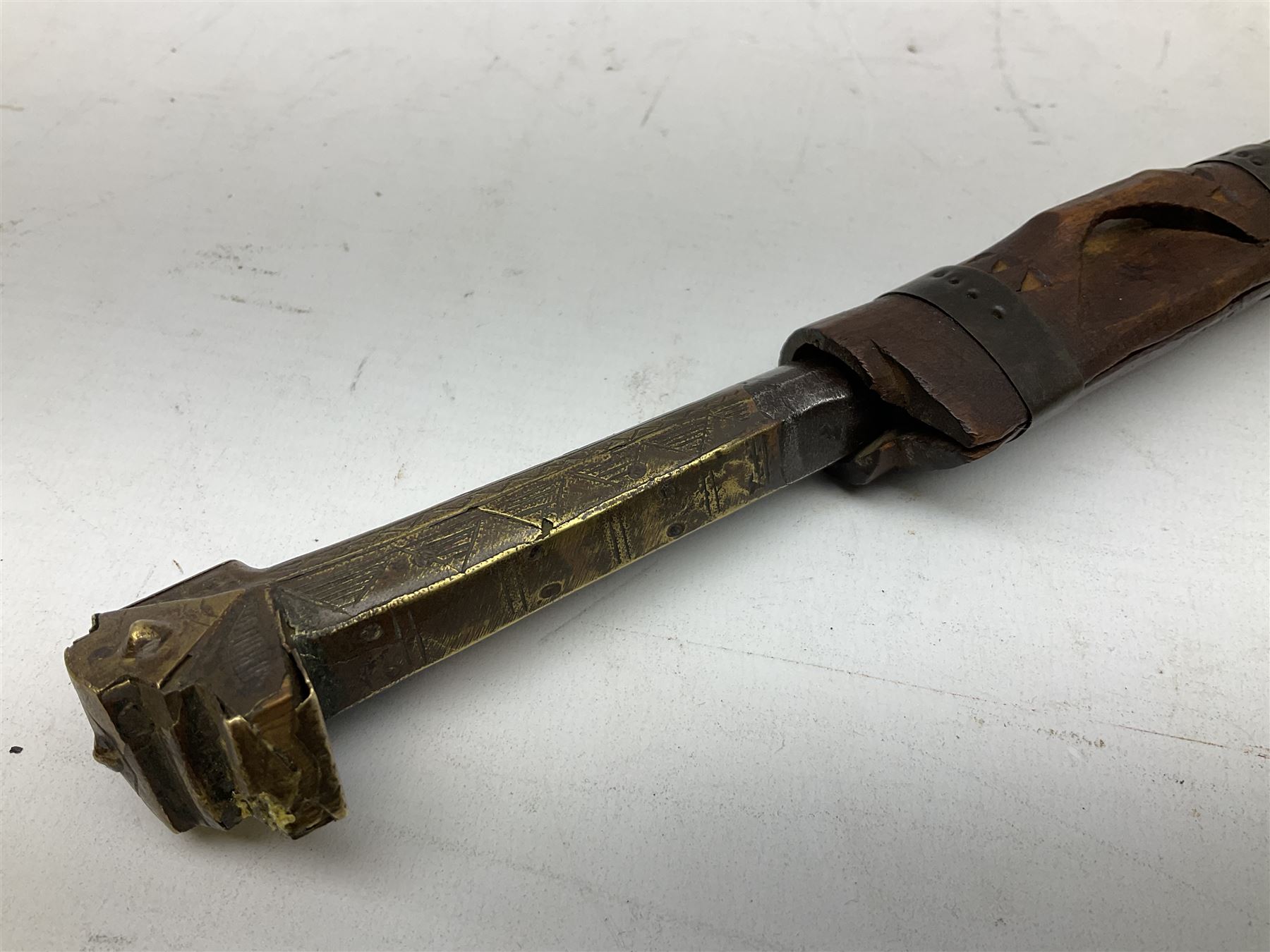 19th century Algerian Flyssa long knife, the 34cm single edged pointed decorative blade inset with yellow metal, chased brass grip with pommel as the snout of a stylised animal and carved hardwood scabbard L45cm overall