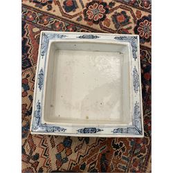 19th century Chinese blue and white planter and stand, each of square slightly tapering and flared form, the planter decorated with figures and precious objects between stylised foliate borders, the stand decorated with landscapes beneath a lipped rim with cell band, planter H28cm D25.5cm, stand H7cm D26cm