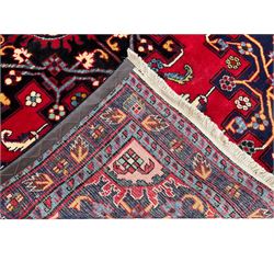 North West Persian Tafresh crimson ground rug, central indigo lozenge medallion with a geometric border and stylised flower heads and contrasting spandrels, guarded border with Bote motifs and repeating geometric shapes